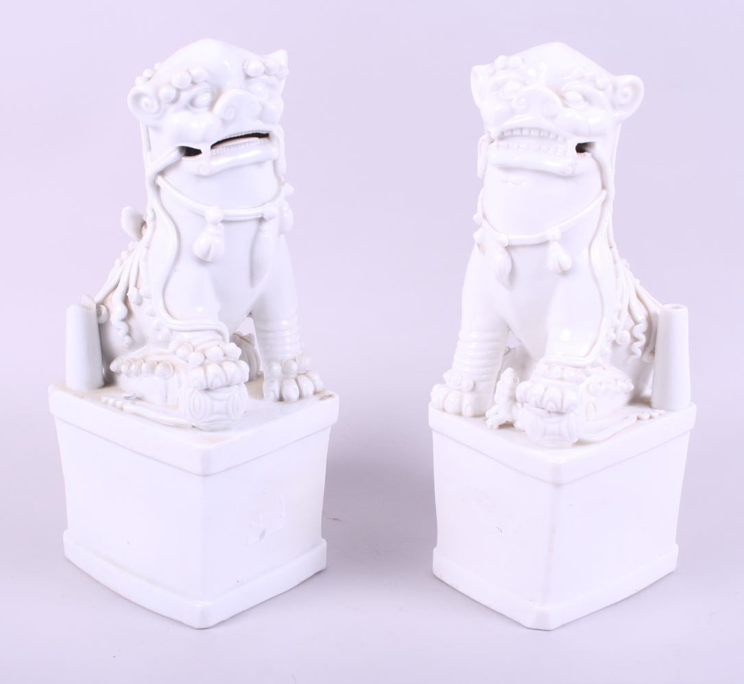 A pair of Chinese porcelain blanc de chine temple lions, on square bases, 11" high