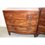 An early 19th century mahogany chest of three long graduated drawers, on bracket feet
