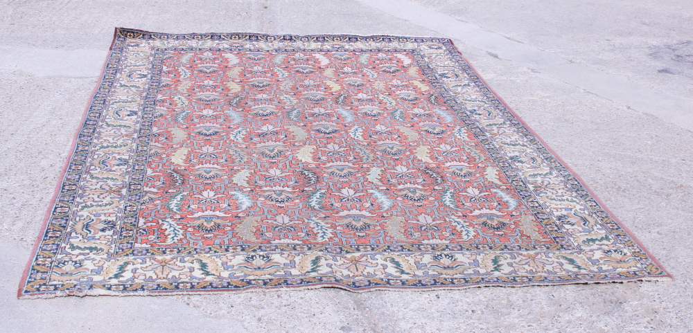 A Persian Tabriz rug of traditional design in shades of blue, pink and natural on a red ground, 132"