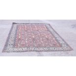 A Persian Tabriz rug of traditional design in shades of blue, pink and natural on a red ground, 132"