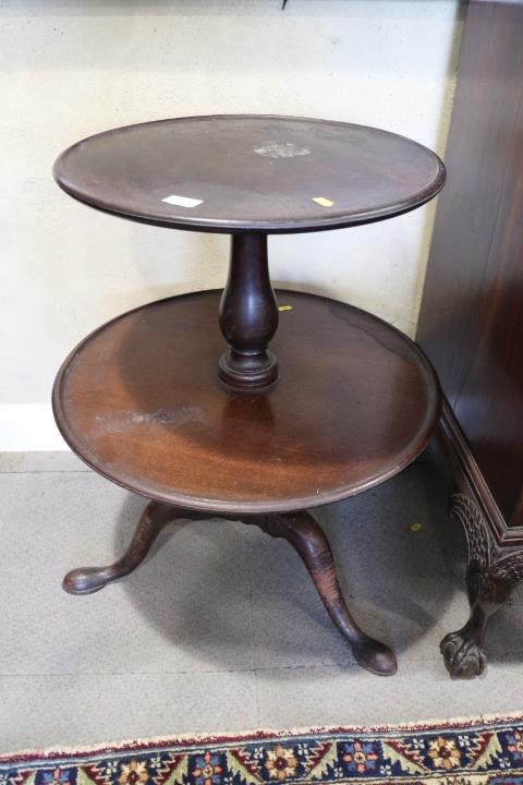 A Georgian mahogany two-tier dumb waiter, on turned column and tripod splay support with pad feet,