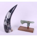 A reproduction axe head and an African big five carved cow horn