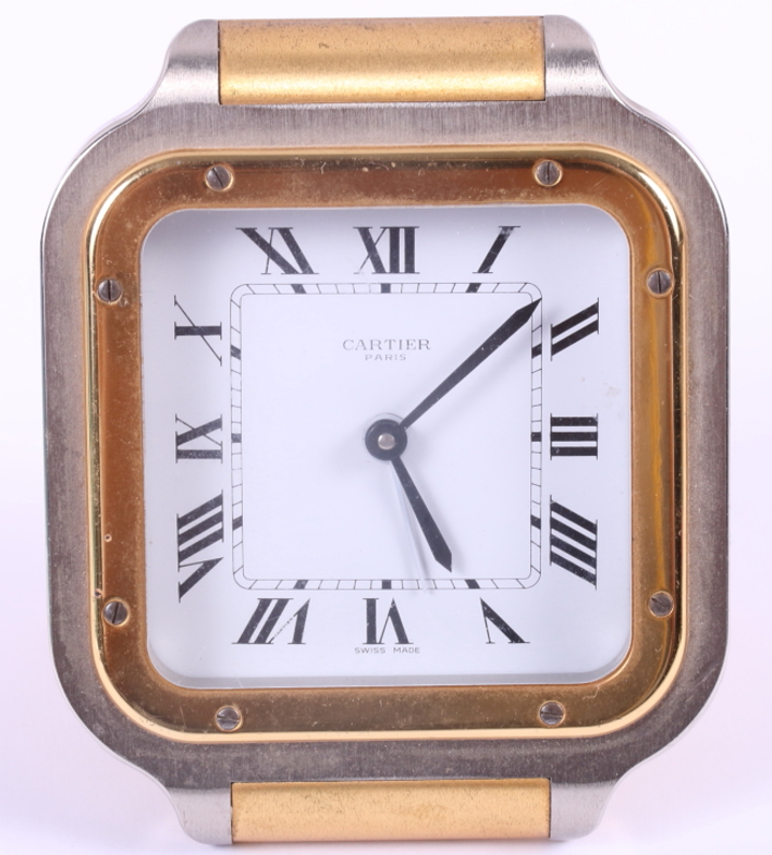 A Cartier steel and gilt cased travelling alarm clock, white enamel dial with Roman numerals and