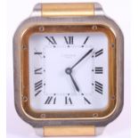 A Cartier steel and gilt cased travelling alarm clock, white enamel dial with Roman numerals and