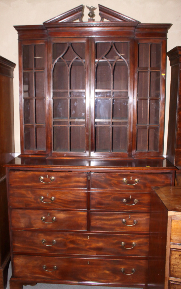 A George III mahogany breakfront secretaire bookcase, the upper section enclosed Gothic lattice