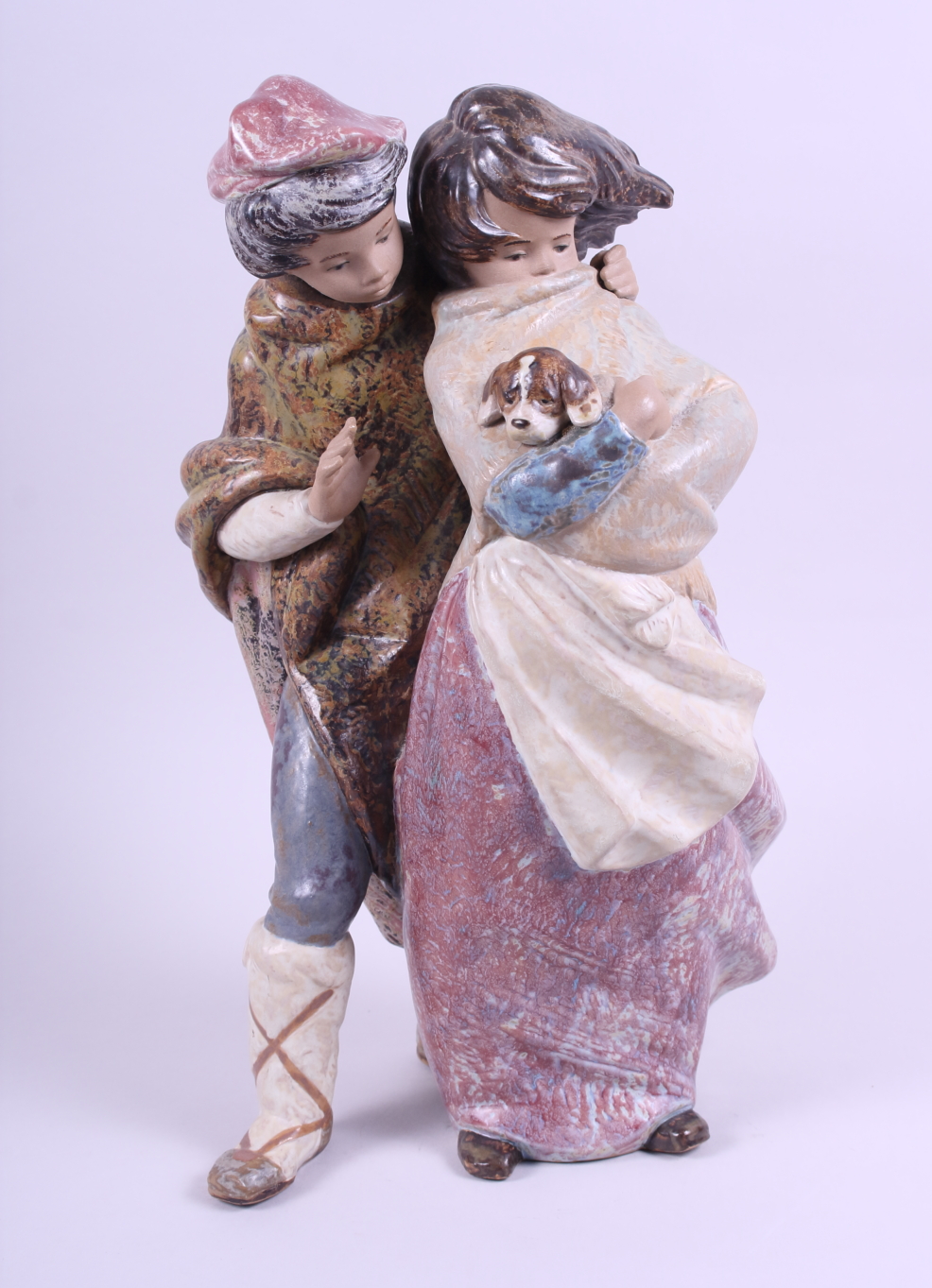 A Lladro Gres figure group of a young boy and girl holding a small dog, 13 12" high