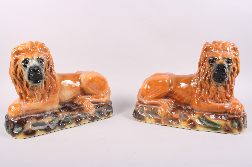 A pair of 19th century Staffordshire lions with glass eyes, 13" wide