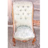A walnut showframe low seat nursing chair with scroll back, on cabriole supports
