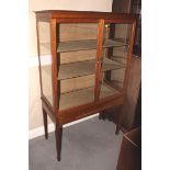 An early 20th century walnut china display cabinet enclosed two doors with cutlery drawer below,