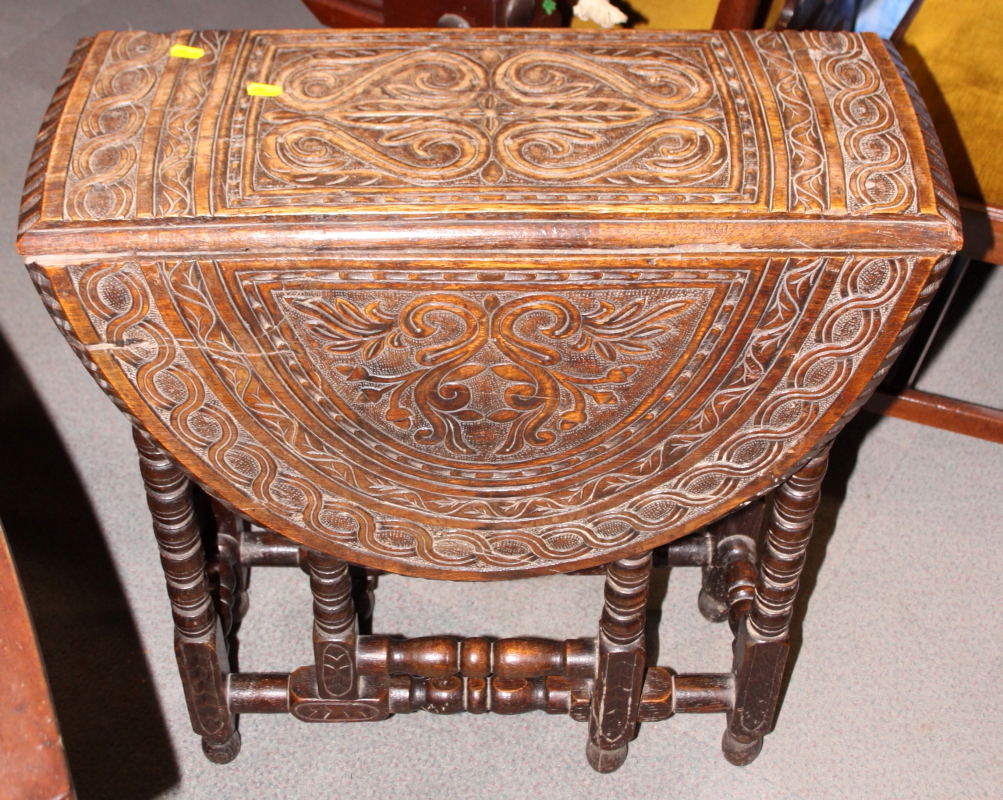 A 19th century carved oak drop leaf table, on bobbin turned supports, 26" wide