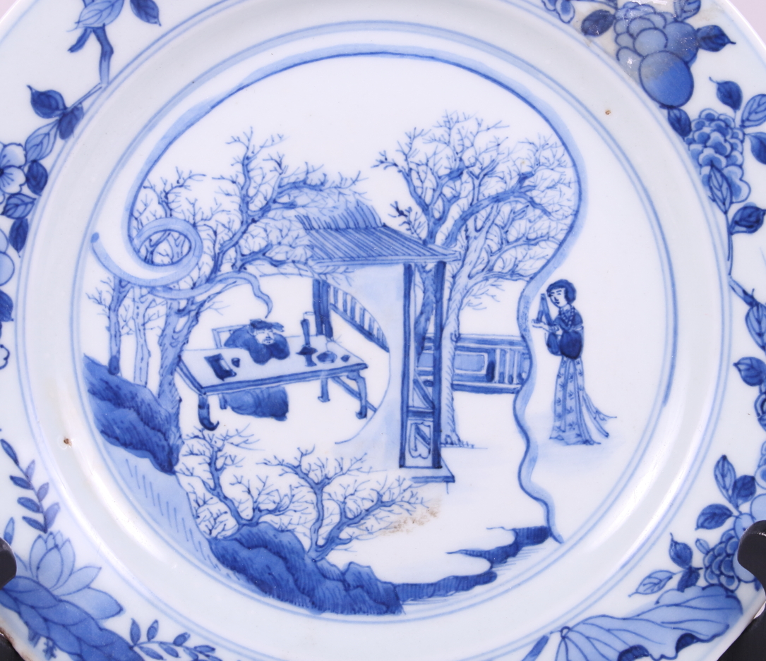 A Chinese blue and white porcelain dish, decorated figures and trees with a floral border, Kangxi - Image 2 of 4
