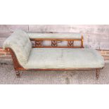 A late 19th century chaise longue with carved scroll end and vase splats to back, upholstered in
