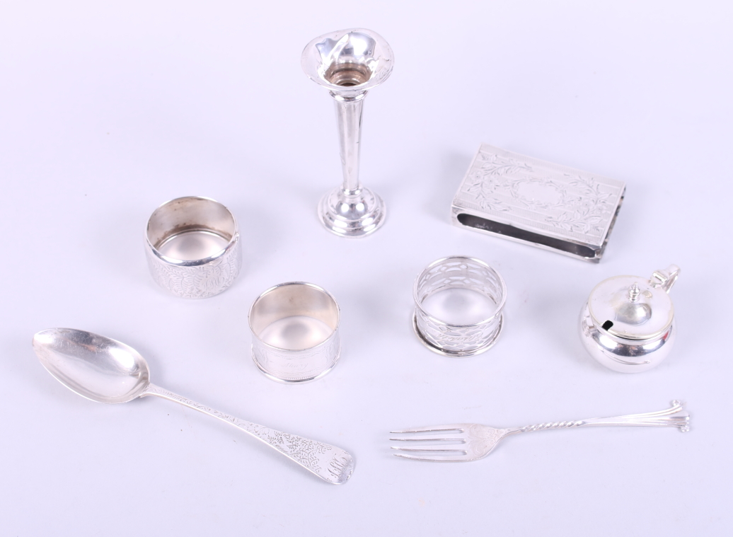 Two silver napkin rings, a silver fork, a silver spoon, a silver match box sleeve, a miniature