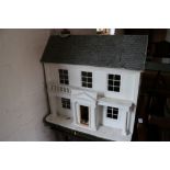 A wood doll's house with classical portico and accessories, 26" wide