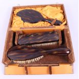 A tortoiseshell dressing table set, comprising a mirror, a clothes brush and a hairbrush, in box (