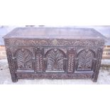 An 18th century oak carved three-panel coffer, on stile supports, 46" wide