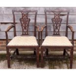 A pair of carved mahogany elbow chairs of mid Georgian design with pierced splats and drop-in seats