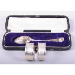 A pair of silver napkin rings and a silver spoon, in case, 1.2oz troy gross