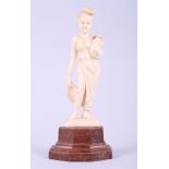 An early 20th century Indian ivory figure of a woman, on hardwood stand, 6 1/4" high