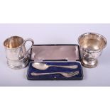 A silver christening mug, a spoon and fork christening set, in case, and a silver plated cup, 5.
