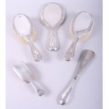 A silver backed three-piece dressing table set, a miniature silver brush and a silver handled shoe