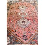 A Caucasian rug with three medallions to the centre pink ground, birds, animals and flowers, in