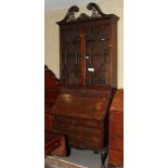 A George III mahogany breakfront secretaire bookcase, the upper section enclosed Gothic lattice