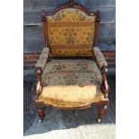 A Victorian oak armchair, upholstered in a floral fabric, on carved fluted supports