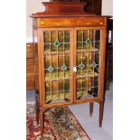 An Edwardian display cabinet with raised back, green coloured glass inserts, on square taper