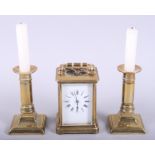 A carriage clock, in brass case, and a pair of brass candlesticks, 5 1/4" high