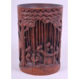 A Chinese bamboo brush pot, deeply carved with figures in a bamboo grove, 8" high