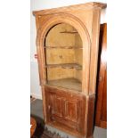 A 19th century pine arch top corner alcove cupboard, the open shelves retaining original casein