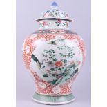 A Chinese porcelain bulbous vase, decorated with panels of birds on a floral ground, and a cover, 15