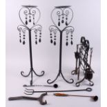 A pair of wrought metal candle holders, and a set of fire implements