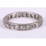 A diamond and white metal full eternity ring with scrolled decoration to the sides, ring size N
