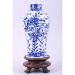 A Chinese blue and white oviform vase, decorated with leaves and dragons, on hardwood stand