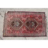 A Caucasian rug with two octagonal guls, on a pink ground, 29" x 49" approx