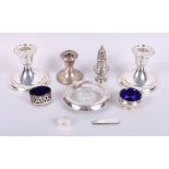 A pair of filled silver candlesticks, a smaller similar, a silver pepper shaker, two silver salts, a