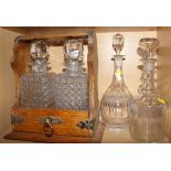 An oak and metal mounted Tantalus, fitted two cut glass decanters and stoppers, together with two