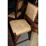 A set of four standard dining chairs of 17th century design, upholstered in a nailed leatherette, on
