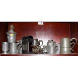 A pewter oil lamp, decorated classical scenes, various pewter tankards, jugs and other items