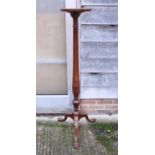 An early 20th century mahogany torchere stand with concave column, acanthus carved base, on tripod