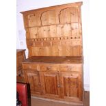 A pine kitchen dresser, fitted six spice drawers over three drawers and three cupboard doors, on