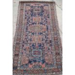 A Caucasian rug with five medallions on a blue ground, 38" x 70" approx