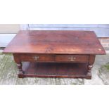 An oak low coffee table, fitted two drawers and under-tier, on turned supports, top 27" x 48" wide