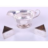 A silver sauce boat and a pair of triangular silver napkin rings, 6.7oz troy approx