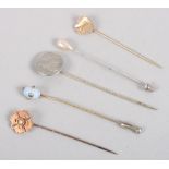 A Victorian yellow metal stick pin set seed pearl and four other stick pins