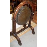 A late 19th century brass dinner gong, in Gothic design oak stand and splay supports, 36" wide