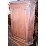 A 19th century oak hanging corner cupboard, with dentil cornice, over panelled door, 26" wide