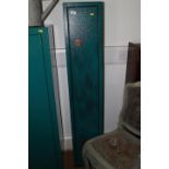 A green painted metal gun cabinet with keys, 11" wide